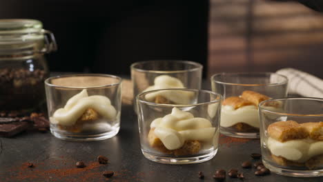 preparing tiramisu in layers in several crystal glasses. hyperlapse