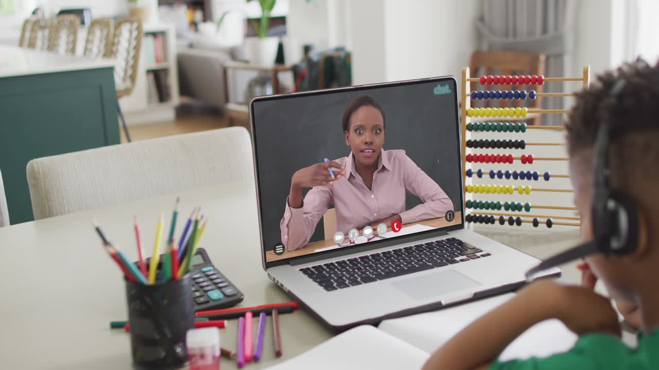Composition of biracial boy on laptop online learning with african american female teacher