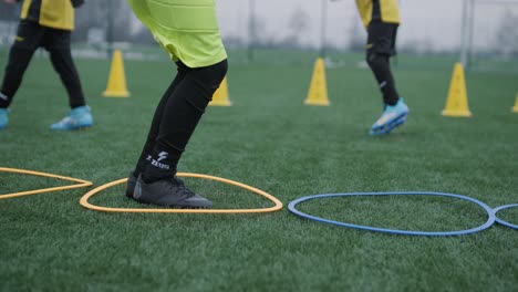 a children's football team trains at the stadium under the guidance of a coach. kids in sports uniforms practice ball exercises, improve technique, and develop teamwork on the green field