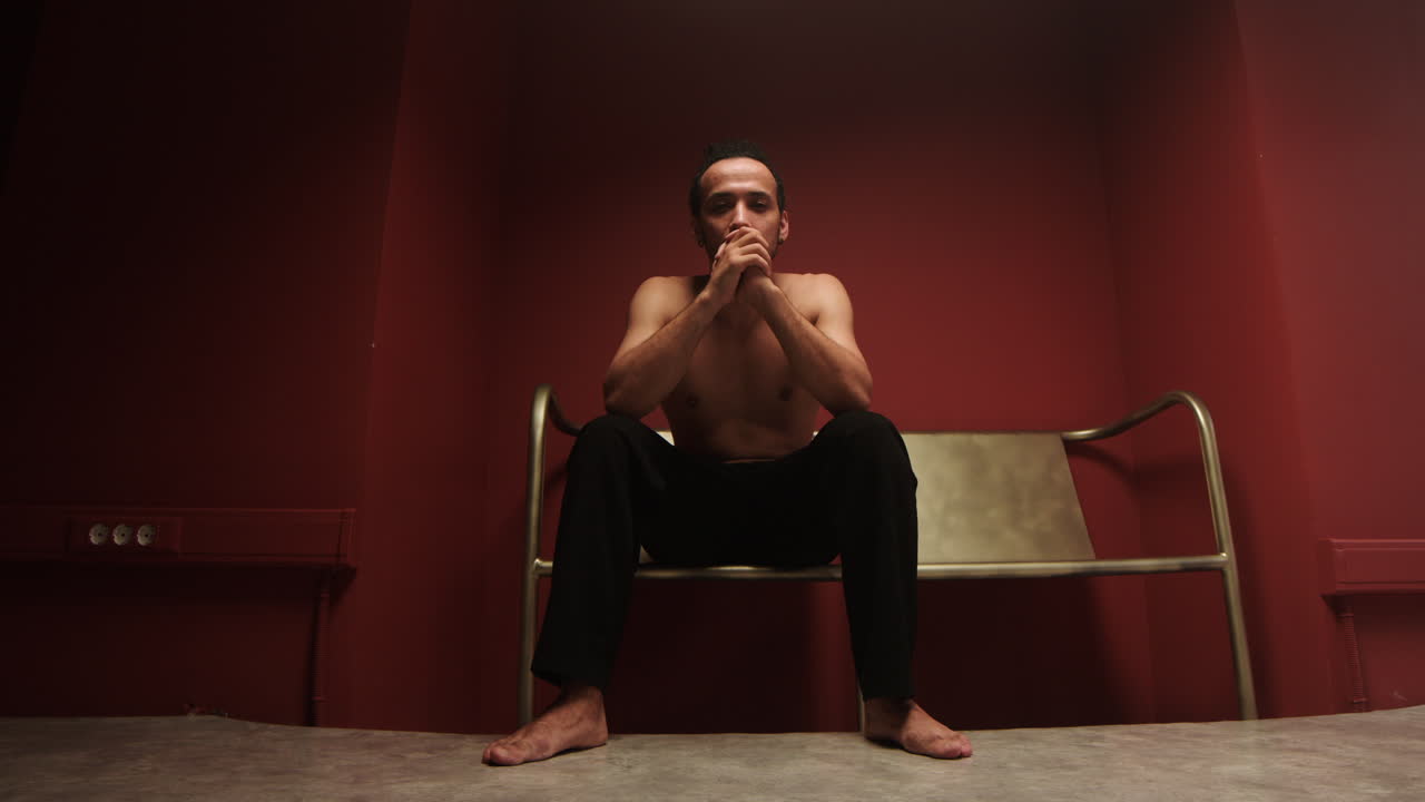 의자 에 앉아 있는 사려 깊은 젊은 남자