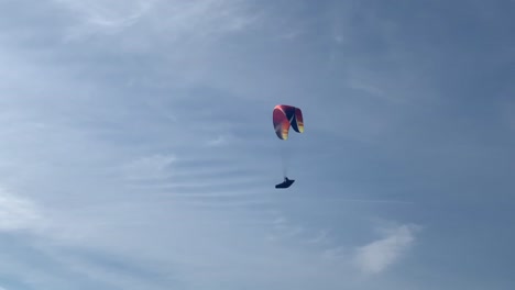 paraglider flying up in the blue sky on a beautiful sunny day on sunday