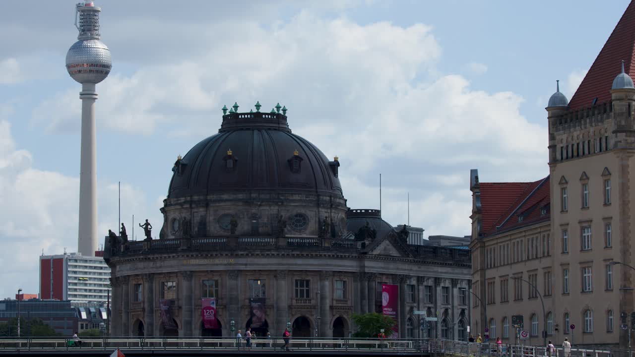 Wide shot pans across historic architecture, river, and cityscape under bright daylight, Berlin, Germany