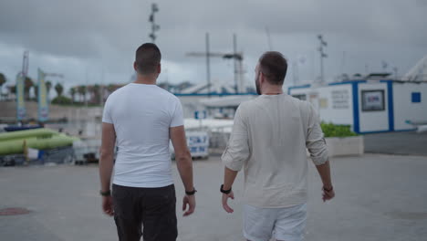 two men walking through a marina