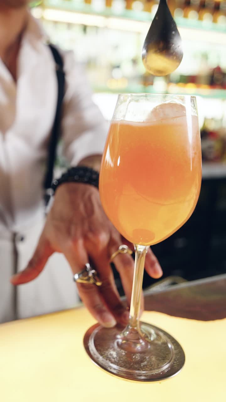 Barman che mescola un rinfrescante cocktail all'arancia in un bicchiere da vino