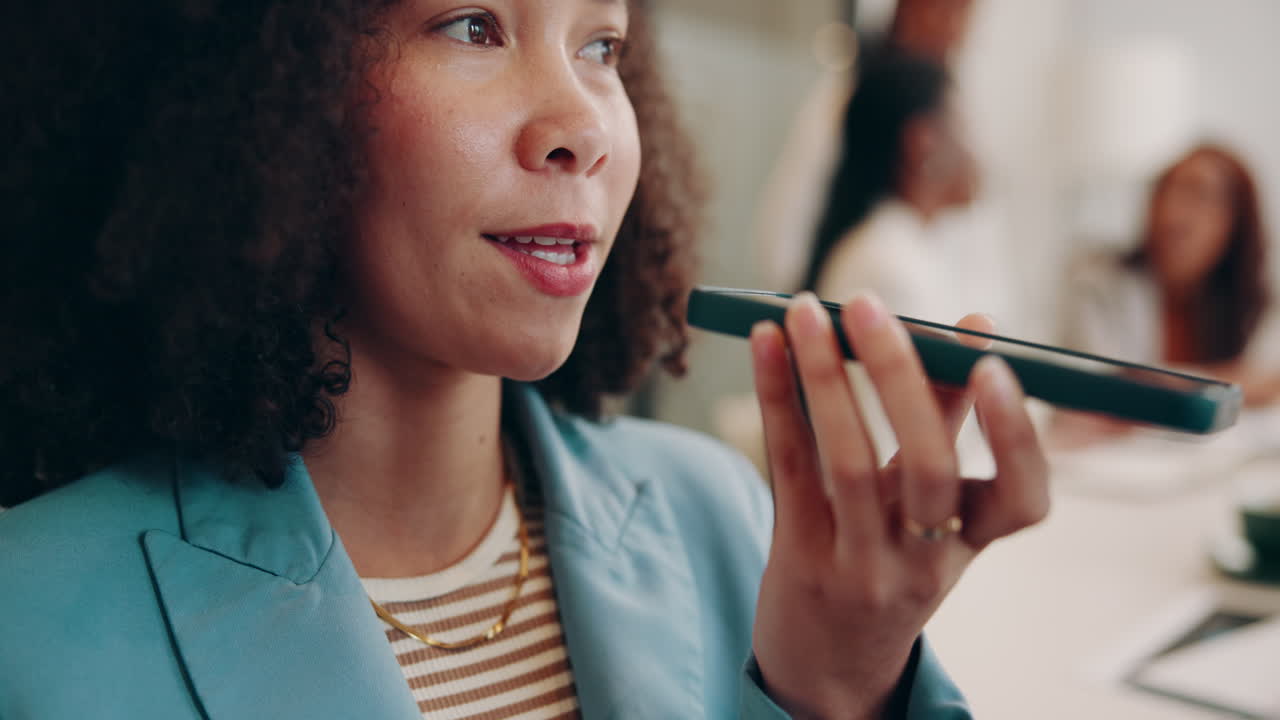 A businesswoman using voice recording on her smartphone in a meeting