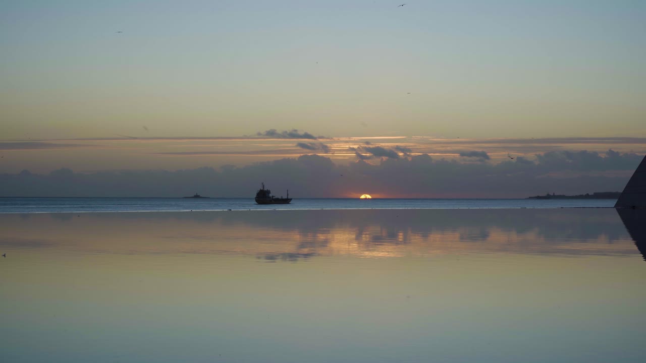 Lisbon tagus river at sunset with boat passing by and lake reflection