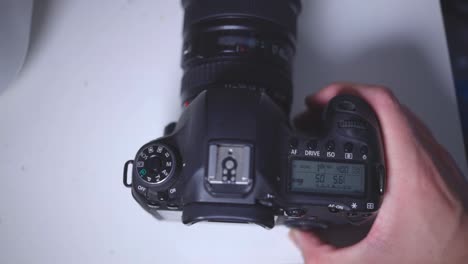 person's hand setting the quick control dial of a camera