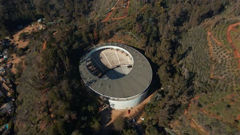 aerial top down orbit over quinta vergara amphitheater and park surrounded by forest in hillside, viña del mar, chile