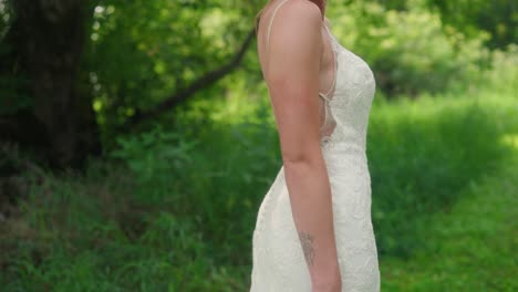 bride posing in forest holding bouquet as camera moves up