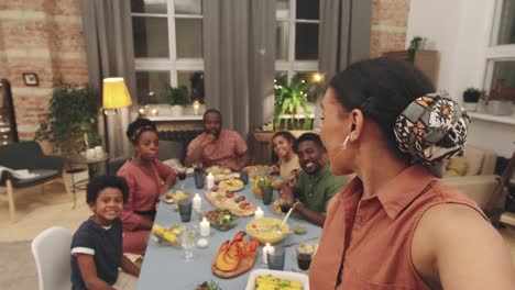 family sitting at a table having dinner at home looking at camera