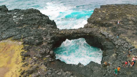 aerial view of the pont natural in mauritius spanning rushing turquoise blue water and connecting two hanging cliffs of the island