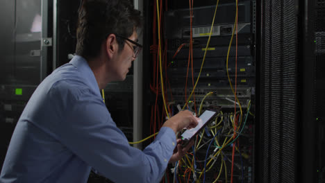 técnico de ti asiático que usa una tableta comprobando el servidor de la computadora