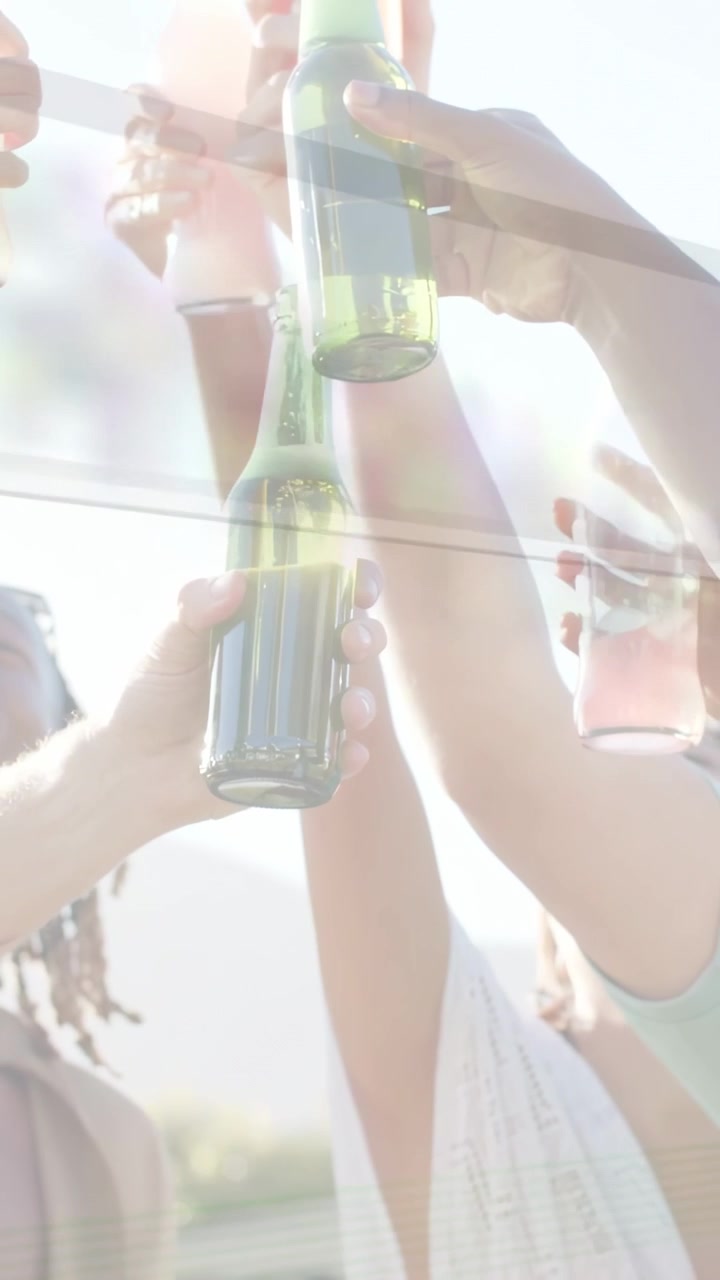 Vertical video: Friends clinking bottles on balcony, raising drinks sparking fizz labels for ads