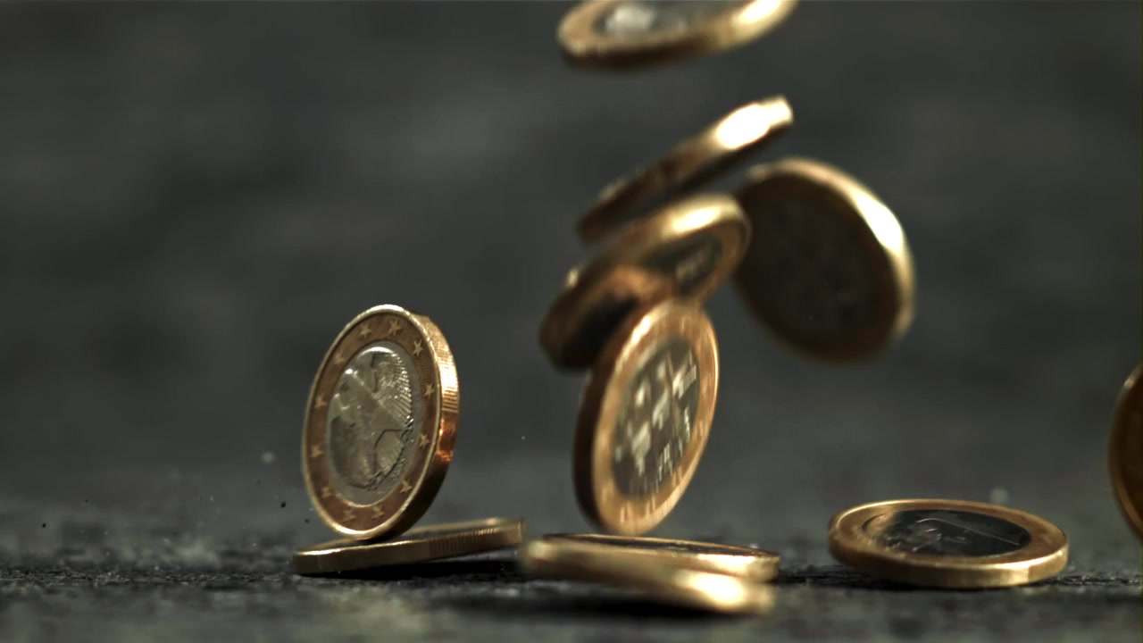 Close-up Slow Motion of Euro Coins Falling and Bouncing on a Dark Surface