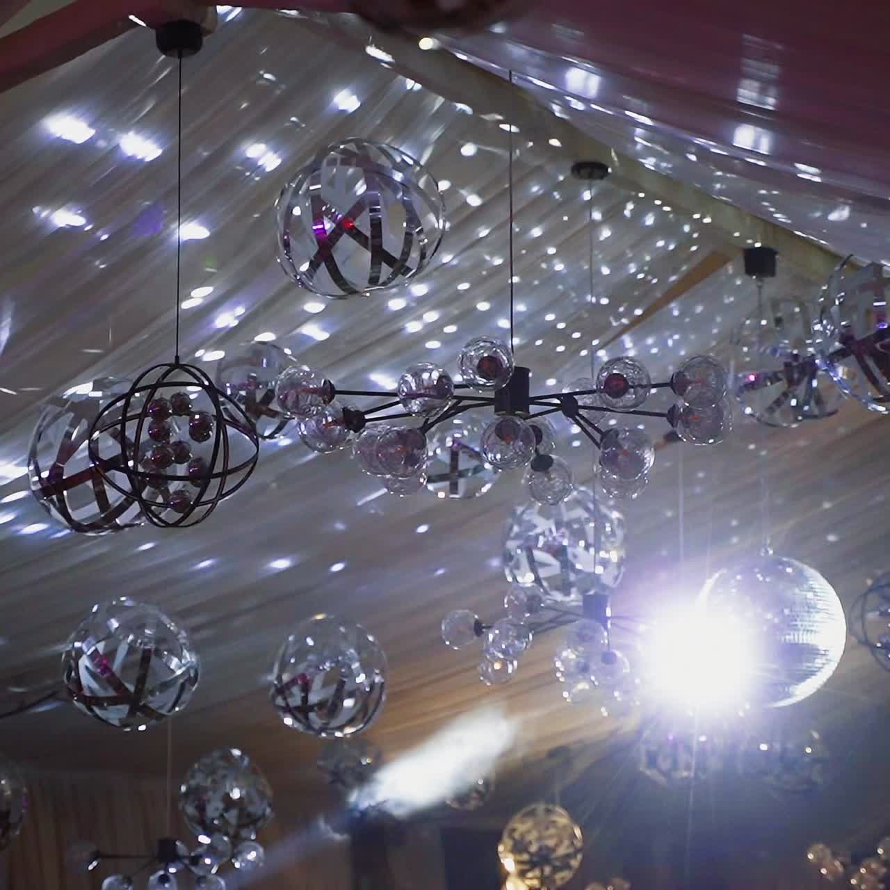 Shimmering ceiling with many glittering balls. Fantastic view of sparkling lights in the restaurant.