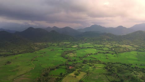 4K-Drohnenaufnahme-Von-Landwirtschaftlichen-Flächen-Mit-Bergkette-Im-Hintergrund