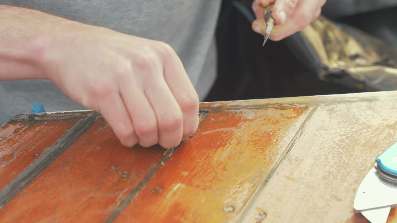 raspado de la vieja sikaflex haciendo reparación de madera barco timonera techo de tablas