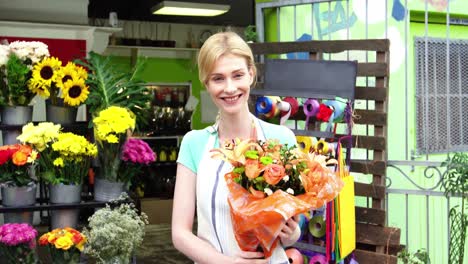 Female-florist-holding-a-bouquet-of-flowers-in-flower-shop