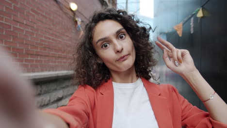 young woman taking a selfie in a city alley