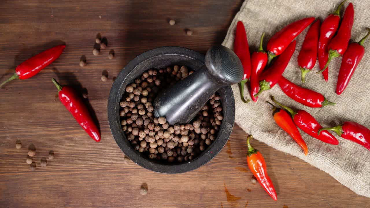 la mano masculina pone pimienta negra en un mortero con un pestillo.