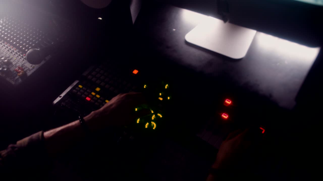 Hipster dj mixing and producing electronic music at recording studio