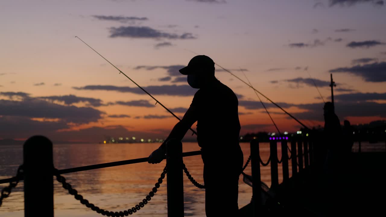 Sagoma Rossastra di Uomo Che Pesca