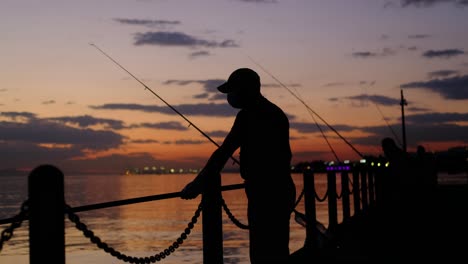 Rötliche-Silhouette-Des-Mannes-Beim-Angeln