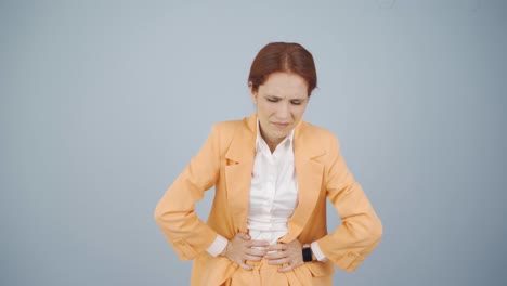 mujer de negocios con dolor de estómago.