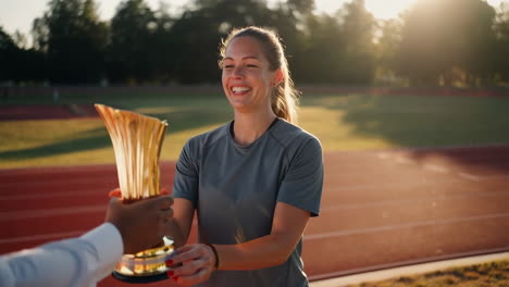 woman receiving a trophy at a track meet