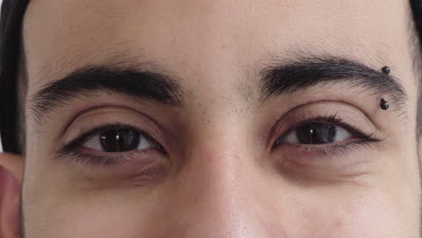 primer plano de un hombre hispano ojos mirando a la cámara expresión feliz usando cejas perforación reflejo visión vista