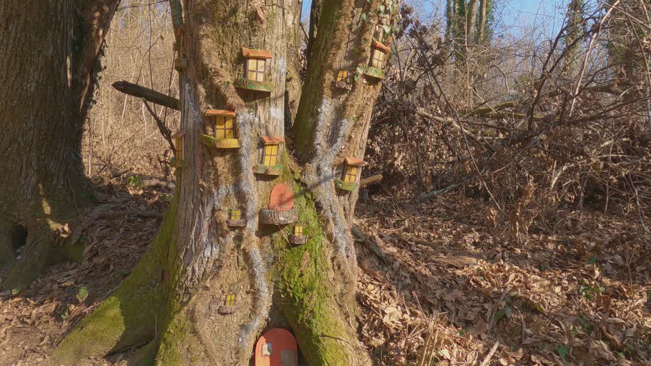 pequeñas casas de elfos de madera sobre troncos de árboles en el sendero invorio de los elfos en italia