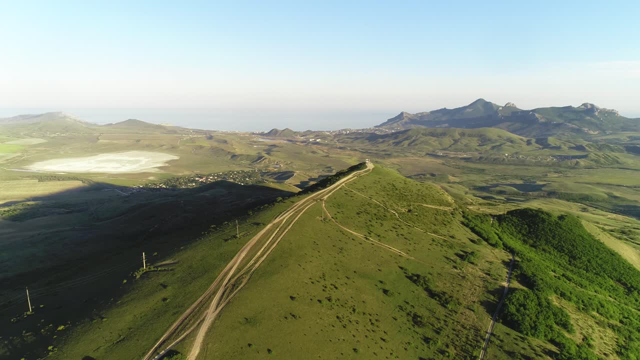 vista aérea de un paisaje montañoso con una carretera que serpentea a través de las colinas