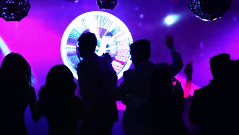 people dancing in a night club with neon lights