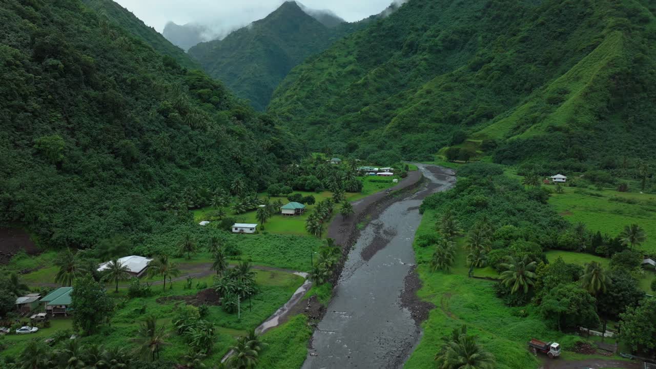 teahupoo tahiti polinesia francesa avión no tripulado aéreo río montañas mañana gris gris lluvioso temporada de niebla húmeda hierba verde final de la carretera punto faremahora pueblo edificios de la ciudad isla movimiento hacia adelante