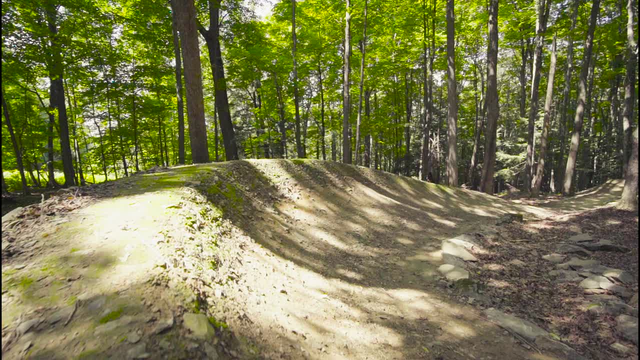 The camera smoothly follows a rider around a berm.