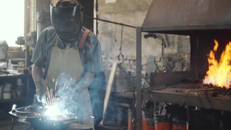 Blacksmith-in-Helmet-Welding-Iron-in-Workshop