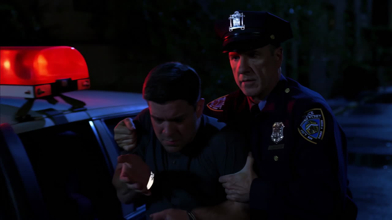 Police Officer Detaining a Man at Night