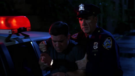 police officer detaining a man at night