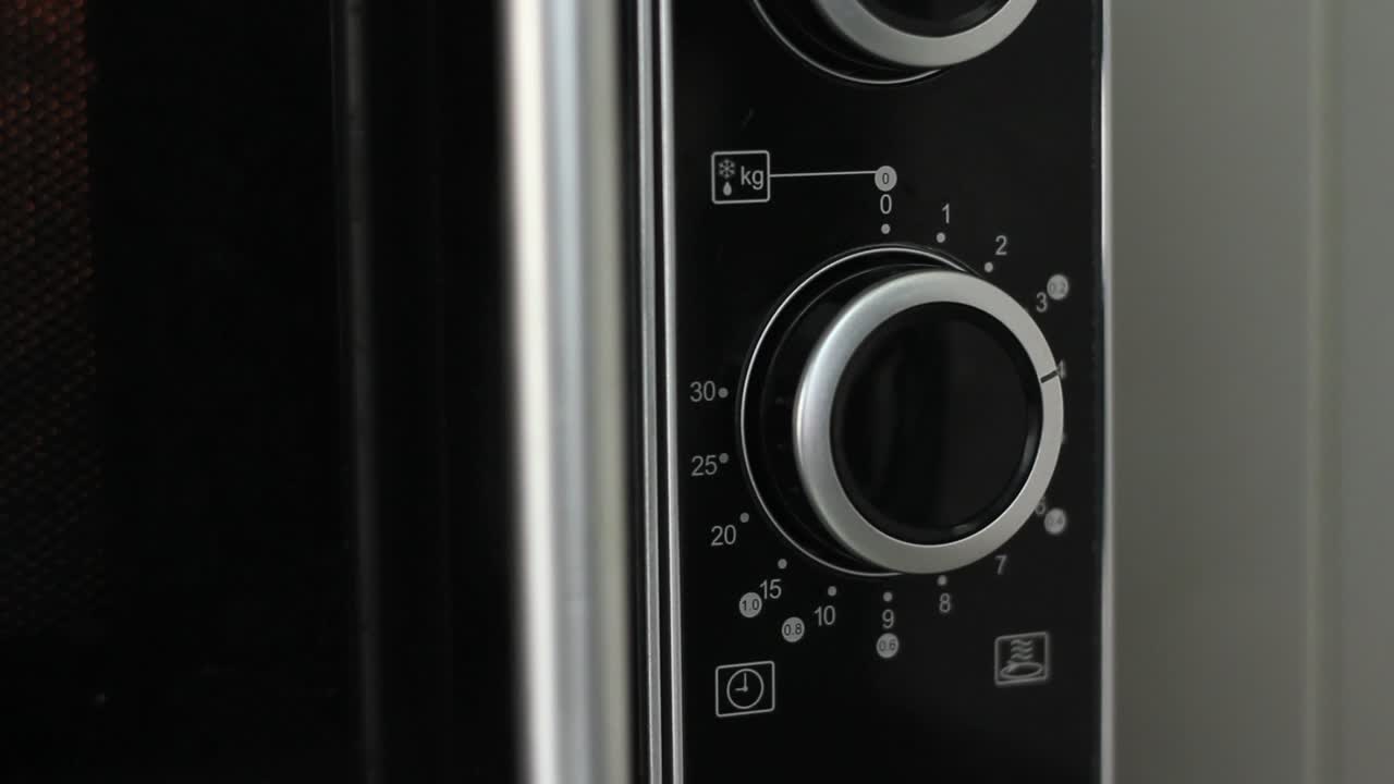 ajuste del temporizador del microondas a cuatro minutos y apagado del microondas - disparo en ángulo cerrado