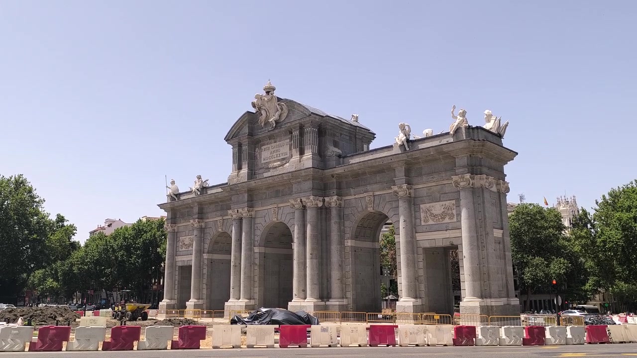 Puerta de Alcalá triumfbue-monument med gadetrafik i Madrid, Spanien. Håndholdt udsigt