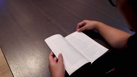 persona leyendo un libro en una mesa
