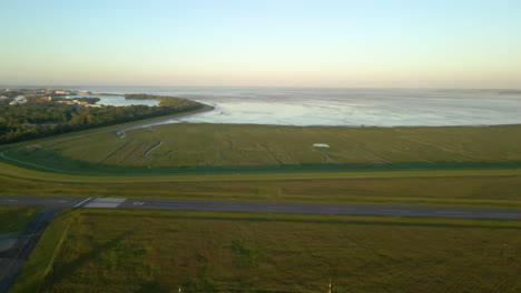 empty runway of jadeweser airport in sande, germany with view of jade bight in background