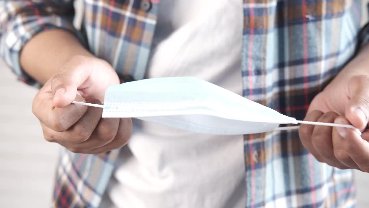 얼굴 마스크를 들고 있는 사람