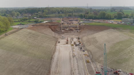 aerial of a megaproject train track construction site, diggers , buldozers and other machinery - railway track hs2