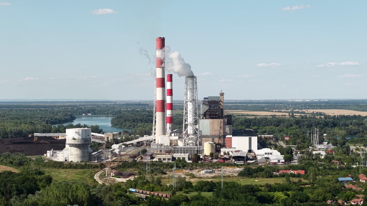 Drone Shot of Coal Fired Power Plant With Smoke From Chimney on Sunny Summer Day