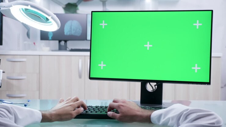Dottore che lavora su un computer con schermo verde