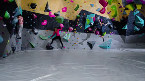 adolescentes haciendo bouldering en un gimnasio