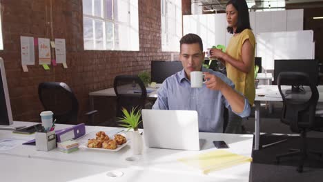 Mixed-race-businesswoman-approaching-to-caucasian-business-colleague-who-drinking-coffee