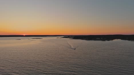 A-boat-speeds-across-the-water-against-the-setting-sun