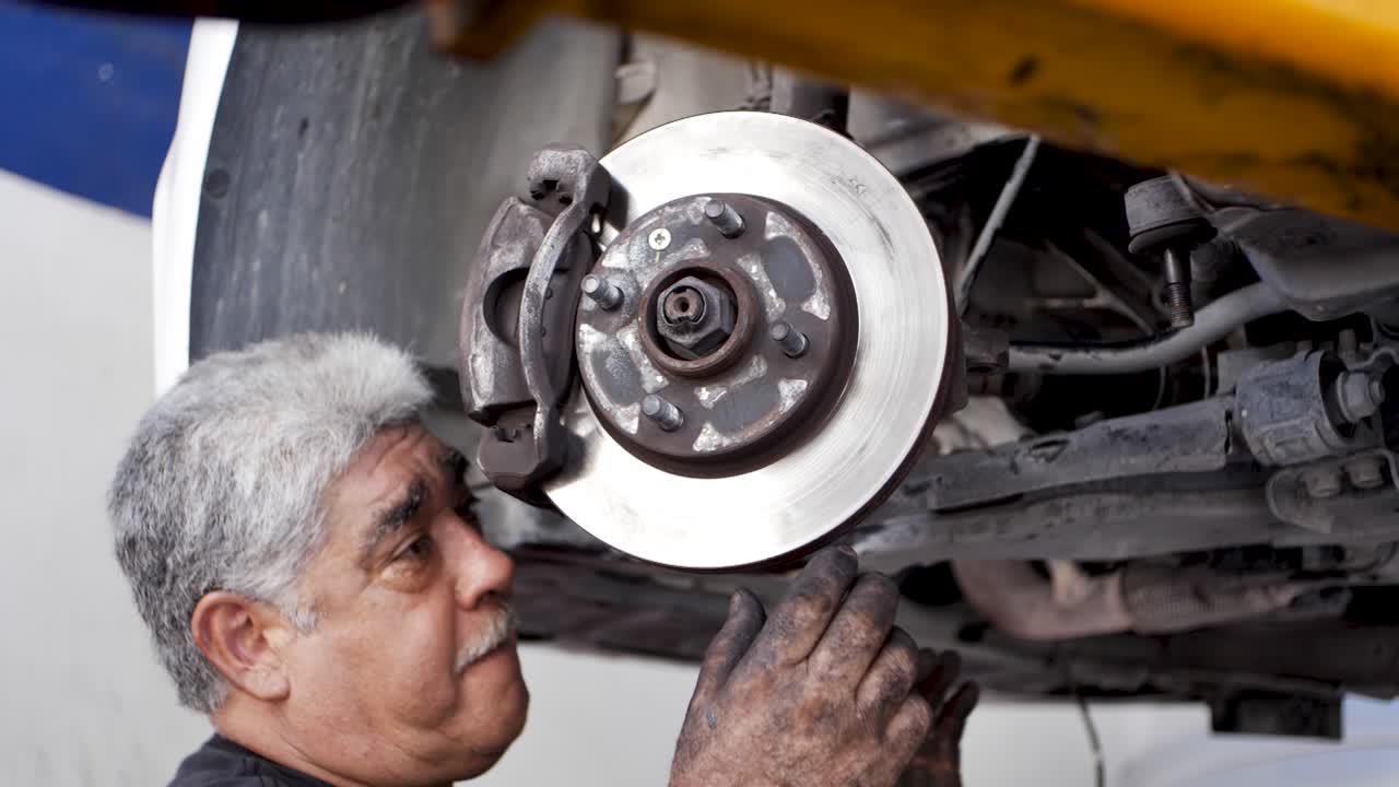 viejo mecánico mexicano canoso calibrando el disco de freno de un automóvil rectificado recientemente en tulum méxico